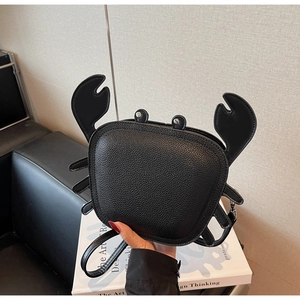 Detail shot of the black crab-shaped crossbody bag featuring textured lychee pattern PU leather