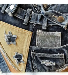 Detail of star-shaped cutout on dark denim with yellow canvas pocket and metal button