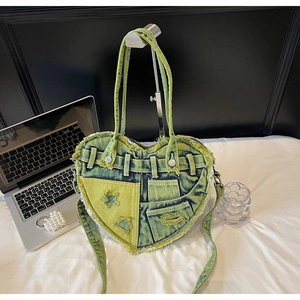 Detail of heart-shaped denim bag featuring distressed edges and star patch accents
