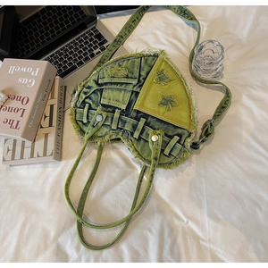 Detailed top view of a heart-shaped denim handbag with vintage washed texture on white bedding
