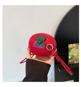 Détail du mini sac bandoulière rouge en forme de pomme avec finition brillante et feuille