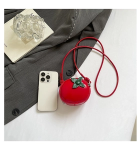 Vue détaillée d'un mini sac bandoulière en forme de tomate rouge avec smartphone de référence