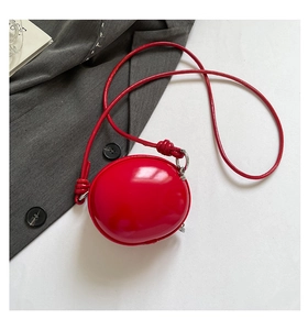 Détail du sac à bandoulière rond rouge en cuir PU avec une finition brillante