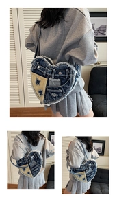 Detail of heart-shaped denim bag with star embroidery and distressed frayed edges