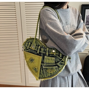 Detail of heart-shaped green denim bag with star cutouts and Y2K distressed style