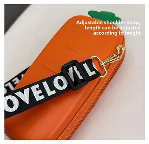 Detail of adjustable LOVE print strap with gold metal hooks on carrot shaped bag
