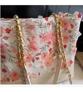 Détails des fleurs en dentelle et des motifs floraux sur le sac fourre-tout crème
