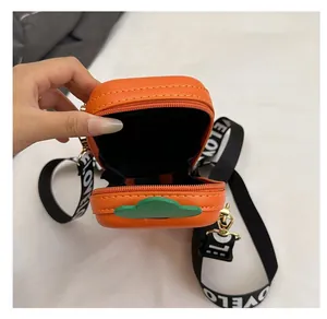 Detail view of the orange rectangular box bag interior with green leaf design
