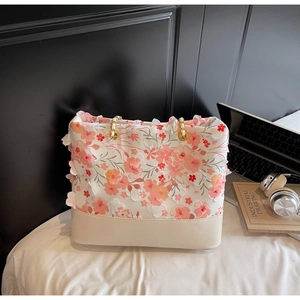 Détail du sac cabas floral avec appliques de fleurs 3D et bandoulière en chaîne dorée