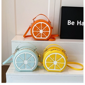 Détail de sacs bandoulière ronds en forme de tranches de citron en orange, jaune et bleu