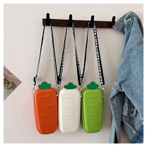 Three carrot-shaped mini crossbody bags in orange, white, and green with LOVE straps