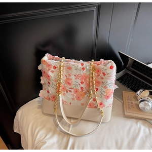 Détail du sac en toile florale avec appliques de pétales 3D et bandoulière en chaîne
