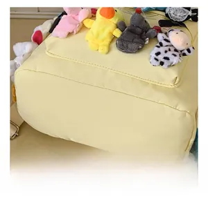 Detailed shot of yellow nylon backpack featuring cute plush animal charms and soft fabric