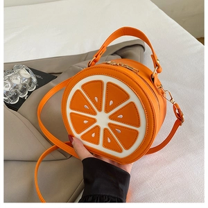 Détail du motif d'agrume et de la fermeture éclair dorée sur ce sac rond orange