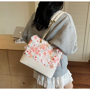 Détails des fleurs 3D brodées roses sur un sac seau en cuir blanc à bandoulière