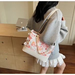 Détail de la broderie florale et des fleurs en dentelle 3D sur un sac beige