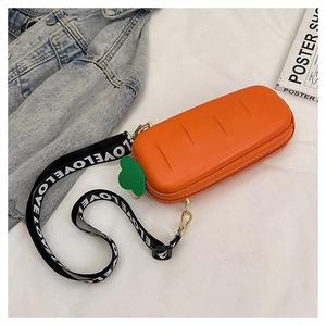 Detail of creative carrot-shaped crossbody bag with green leaf zipper and LOVE strap