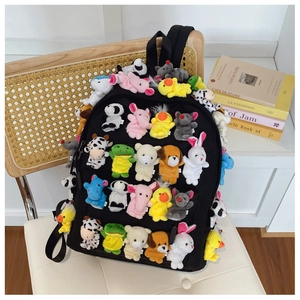 Close-up of black canvas backpack decorated with diverse cute plush animal finger puppets