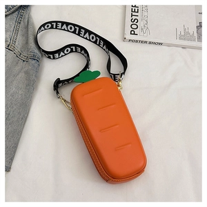 Detail of creative carrot-shaped crossbody bag with a leafy top and a LOVE printed strap