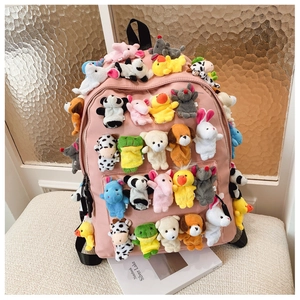 Detailed shot of pink canvas backpack featuring various cute plush animal puppets ornaments