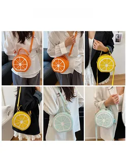 Three fruit-shaped crossbody bags in orange, lemon, and lime designs shown on a model