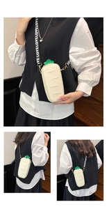 Detail of creative bread-shaped crossbody bag with white body and green leaf accents