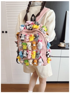 Detail view of pink backpack adorned with various cute mini plush animal toys