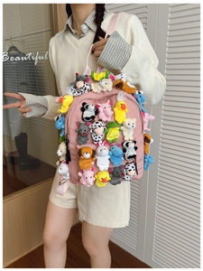 Detailed view of a pink backpack adorned with various cute mini animal plush charms