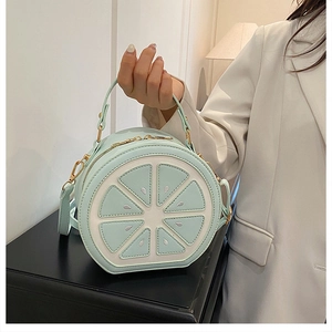 Vue détaillée du sac rond vert menthe avec motif citron vert et boucles dorées