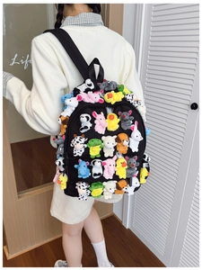 Close-up of black backpack covered with various cute plush animal finger puppets