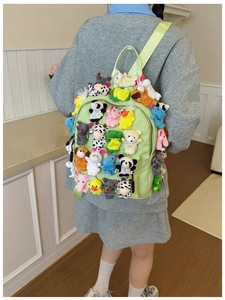 Close-up of light green backpack decorated with many small plush animal dolls