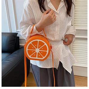 Détail du sac bandoulière orange rond avec texture de fruit réaliste et design
