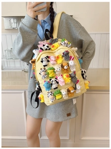 Canvas backpack detail featuring various colorful plush animal finger puppets decoration