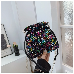 Macro detail of colorful sequins on fashionable drawstring bucket bag with gold chain strap