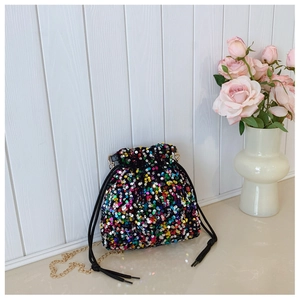 Close-up of colorful sequin bucket bag featuring a gold chain and black drawstring closure
