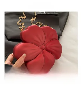 Detail of red flower evening bag with 3D petals and golden chain shoulder strap