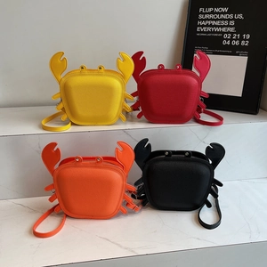 Cute cartoon crab crossbody bags in four vibrant colors on a white marble display