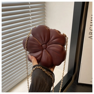 Detail of flower-shaped crossbody evening bag with quilted PU leather and gold chain