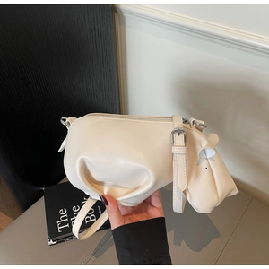 Vue d'un sac bandoulière crème en forme d'hippopotame avec texture en simili cuir