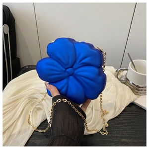 Macro detail of royal blue acrylic flower clutch bag with ornate 3D petal texture