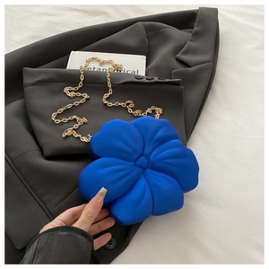 Detail of royal blue 3D flower evening bag with elegant gold chain strap on blazer