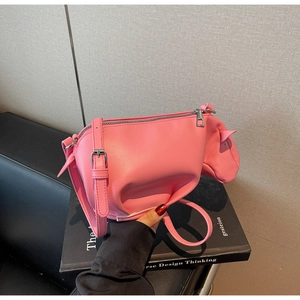 Vue détaillée d'un sac bandoulière rose en forme de veau avec similicuir lisse et zip argent