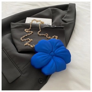 Detailed shot of royal blue flower-shaped acrylic crossbody bag with a gold metal chain strap