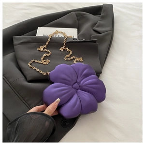 Detailed close-up of a purple flower-shaped evening bag with a golden chain strap