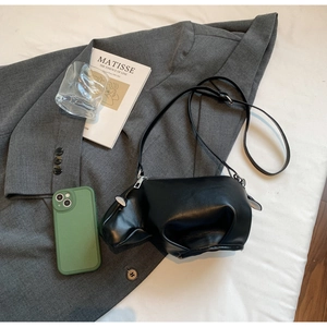 Détail du sac à épaule noir en forme d'hippopotame avec fermeture éclair en métal argenté