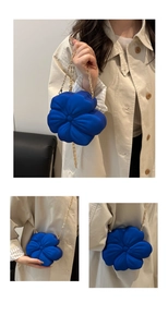 Three-way view of blue floral evening bag featuring 3D petals and golden chain strap