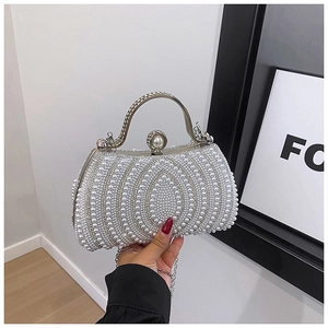 Detail view of wave-patterned faux pearl evening bag with silver handle and pearl clasp