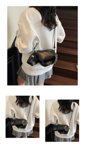 Détail du sac bandoulière hippopotame noir créatif porté avec une tenue décontractée