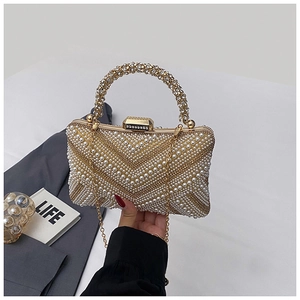 Close-up of luxury pearl and rhinestone evening bag with elegant gold metal frame and handle