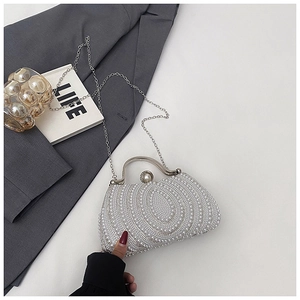 Detail of luxury pearl evening clutch with silver handle and metallic chain strap